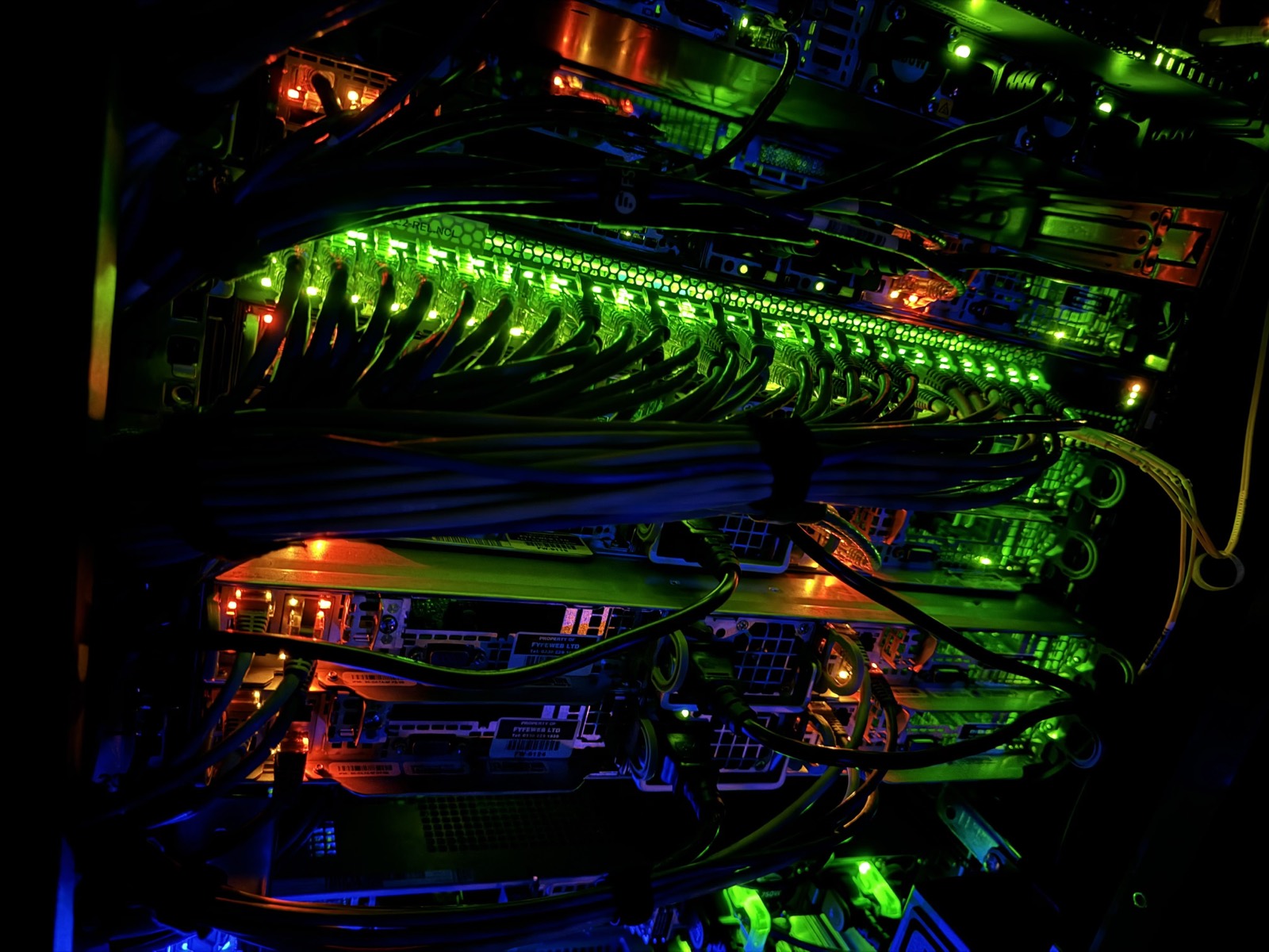 Servers and network switches lit up inside a FyfeWeb data centre rack